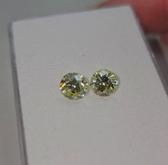 GIA certified matched pair of 2 round natural yellow diamonds.