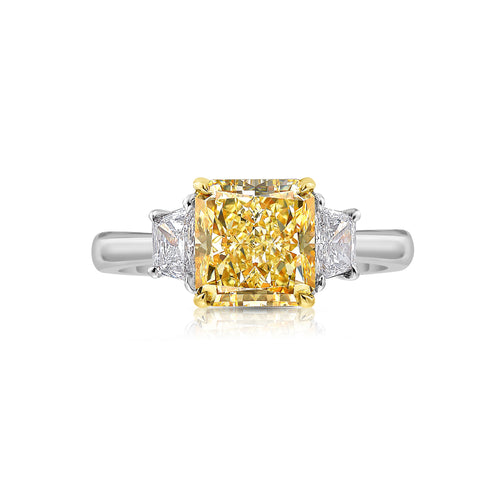 Radiant Fancy Yellow diamond engagement ring with VS1 clarity and white trapezoid accents.