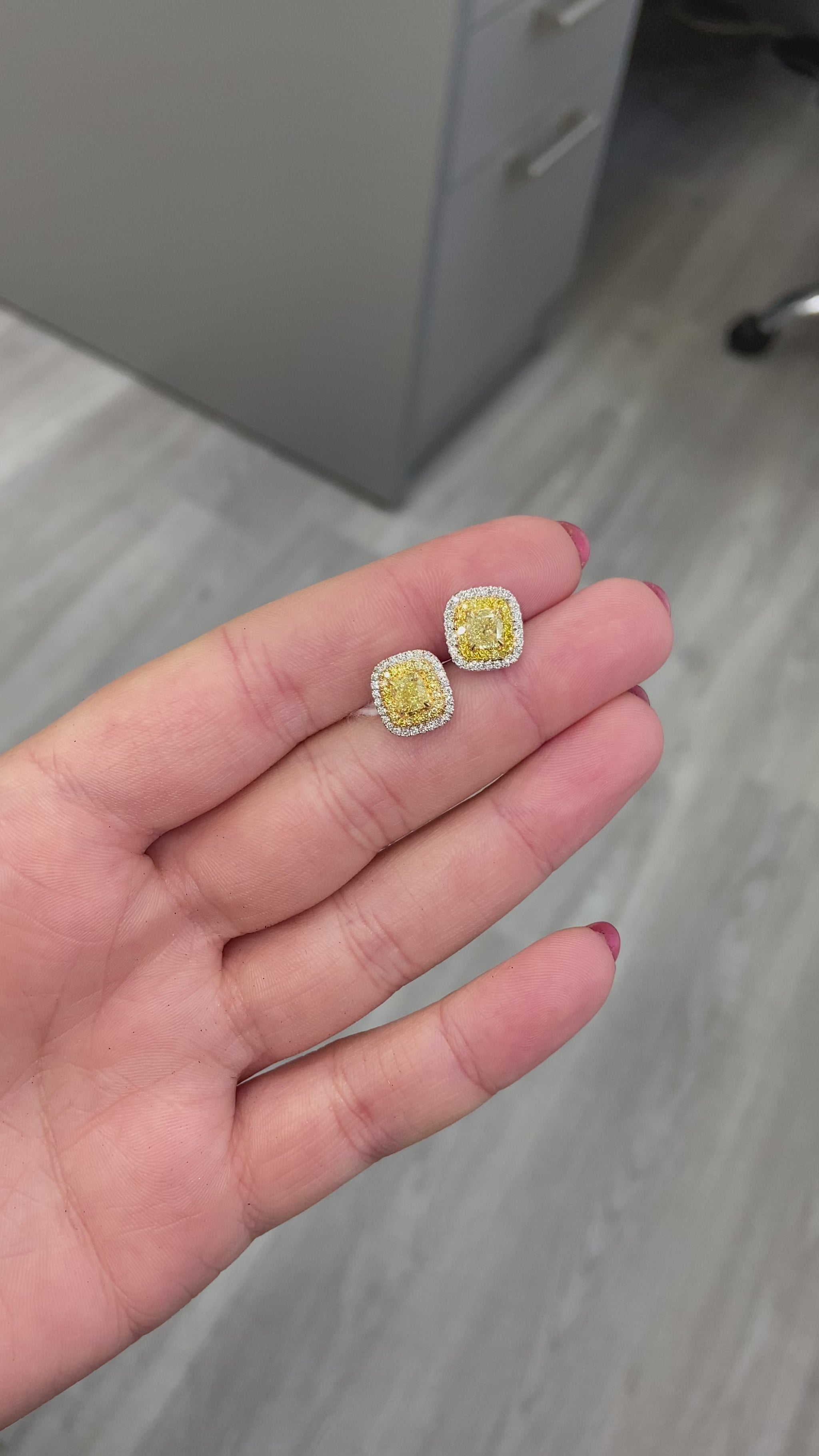 Classic diamond studs made bolder. In the center a vibrant fancy yellow cushion surrounded by a double halo. Fancy Yellow Cushion Studs 1.38 carat total diamond weight VS Clarity Center diamonds are 0.50ct each Surrounded by fancy yellow and white diamond. Set in 18k Gold