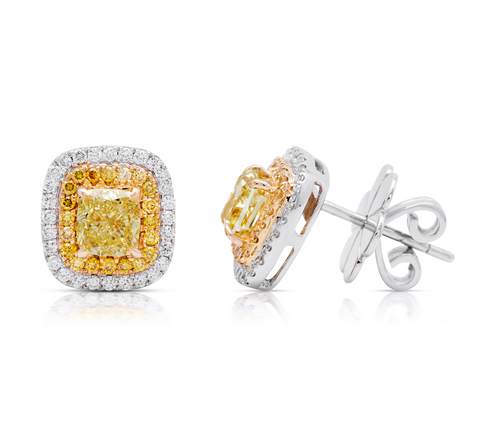 Classic diamond studs made bolder. In the center a vibrant fancy yellow cushion surrounded by a double halo.  Fancy Yellow Cushion Studs 1.38 carat total diamond weight VS Clarity  Center diamonds are 0.50ct each  Surrounded by fancy yellow and white diamond.  Set in 18k Gold.