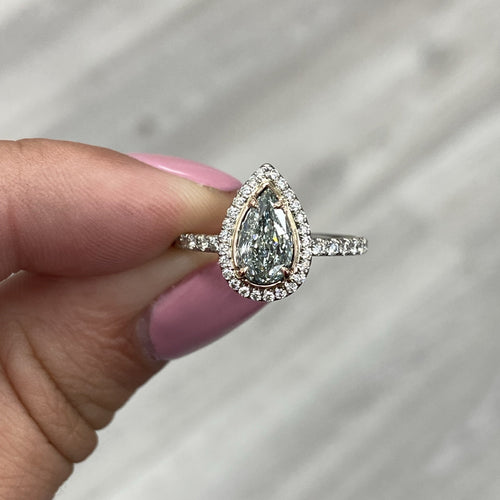 Green pear-shaped diamond ring with VS2 clarity, accented by a pink diamond halo design.