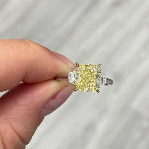 Yellow cushion-cut diamond ring with VS1 clarity, GIA certified, set in an elegant design.