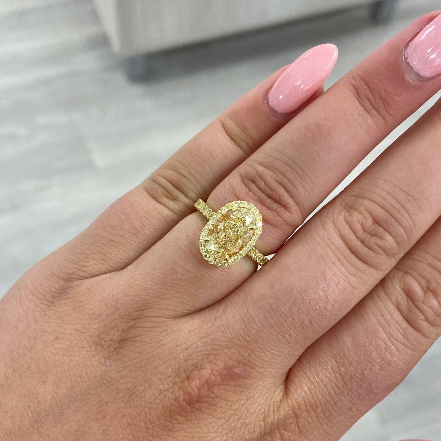 Light Yellow Oval diamond ring set in 18 karat yellow gold with yellow round diamonds.